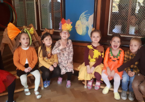 na zdjęciu dzieci z grupy ,,Misie” siedzące na ławeczkach i oczekujące na rozpoczęcie balu.