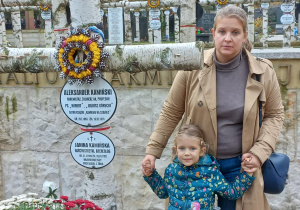 Dziewczynka z mamą zapalają znicze na grobie żołnierza AK Aleksandra Kamińskiego, autora książki „Kamienie na szaniec”, oraz jego żony Janiny Kmińskiej.
