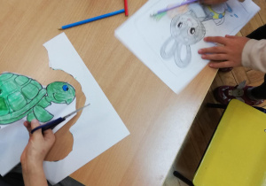 dzieci kolorują i wycinają z papieru różne gatunki zwierząt
