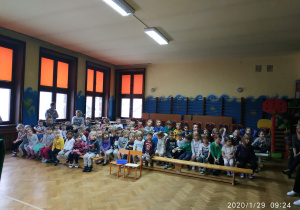 przedszkolaki siedzące na ławkach podczas oglądania przedstawienia