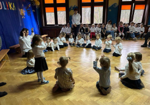 dzieci z grupy pierwszej siedzą w kole wraz z nauczycielem