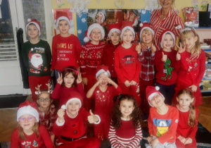 Dzieci przedszkolne ubrane w kolory czerwieni pozują do zdjęcia grupowego.