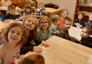 dzieci siedzą przy stolikach