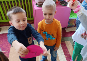 Na zdjęciu chłopiec trzyma połączone połówki serca.