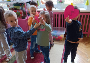 Na zdjęciu dzieci trzymają połączone połówki serca.