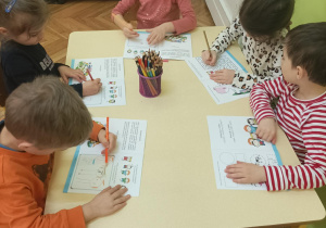 Dzieci uzupełniają mleczne książeczki