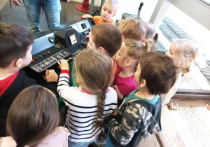 Dzieci przyciskają guziki na pulpicie