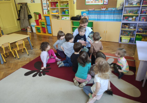 Mama Antka wraz z dziećmi podczas czytania książki