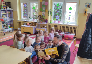tata Kai wraz z dziećmi podczas czytania książki