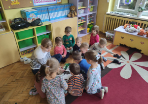 Mama Kazi wraz z dziećmi podczas czytania książki