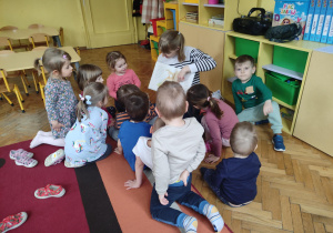 Mama Kazi wraz z dziećmi podczas czytania książki