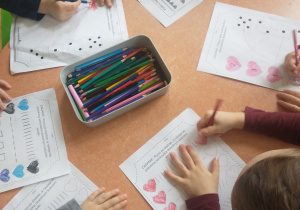 Dzieci wykonują walentynkowe karty pracy.