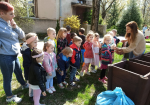 dzieci segregują śmieci wraz z nauczycielką