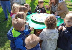 dzieci rozwiązują zagadki przy magiczny kole