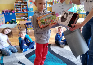 chłopiec prezentuje dyplom i nagrody, które zdobył na konkursie