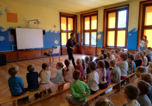 grupa IV, V i VI oglądają na sali gimnastycznej występ iluzjonisty