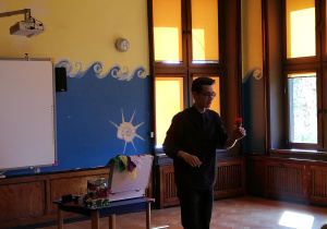 iluzjonista ze sztucznym kwiatem w ręku