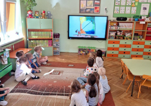 Dzieci oglądają na tablicy multimedialnej film o tytułowej „Kropce".