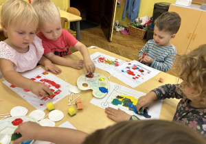 Na zdjęciu dzieci wykonują prace plastyczne z użyciem akcesoriów kosmetycznych.