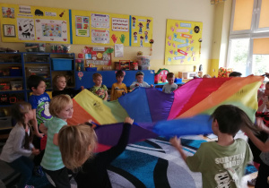 dzieci w klasie bawią się z chustą animacyjną