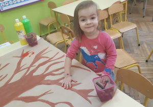 na zdjęciu dziewczynka podczas wykonywania pracy plastycznej ,,Drzewo”