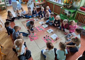 Dzieci na zdjęciu dopasowują liście i dary jesieni do odpowiednich drzew.