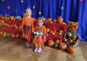 Dziewczynki pozujące na tle jesiennej dekoracji z dyń