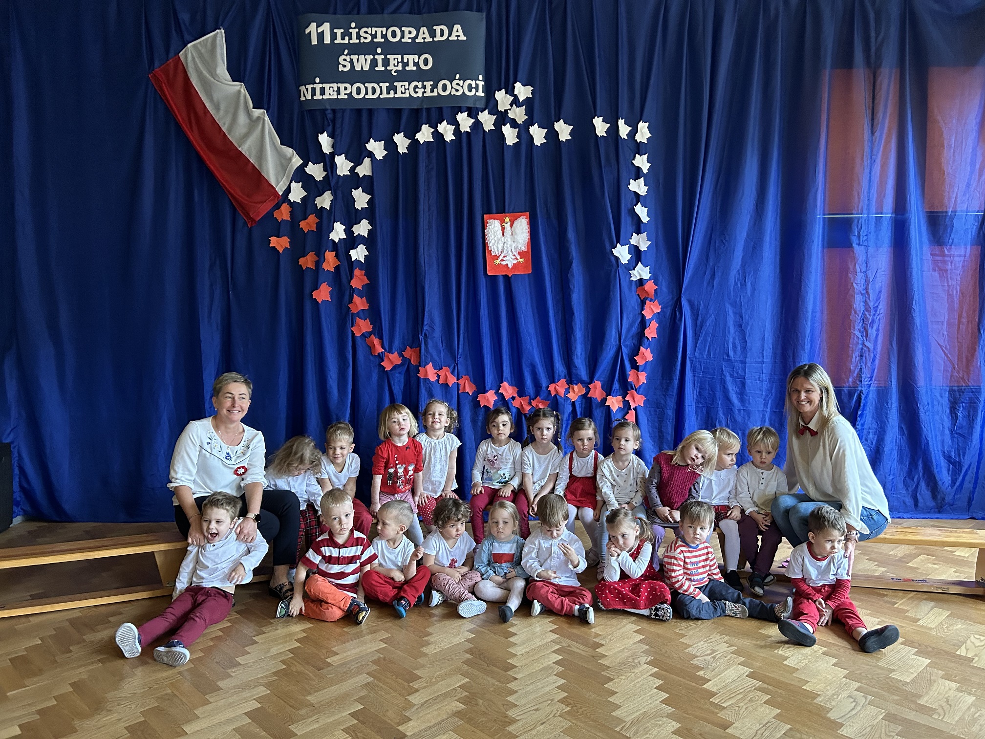 Na zdjęciu grupa Lisków z paniami na tle dekoracji z okazji Święta Niepodległości.
