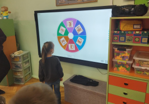 dziewczynka podczas wykonywania zadania z wykorzystaniem tablicy multimedialnej
