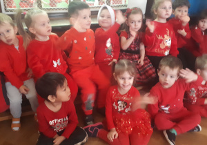 zdjęcie przedstawia dzieci z grupy misie w czerwonych strojach oczekujące na Bal