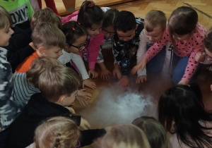 Dzieci siedzące na podłodze oglądające" dymny dywan".