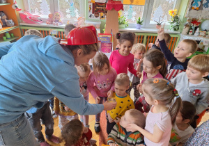 Pani nauczyciel pokazuje dzieciom jak wygląda ocet który będzie użyty do eksperymentu „Wybuch wulkanu”.