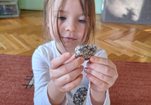Dziewczynka ogląda kolorowy kamień.