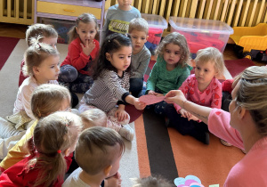 Nauczycielka rozdaje dzieciom walentynki.