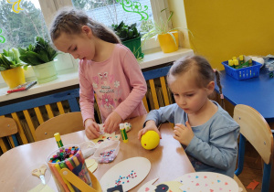Dwie dziewczynki podczas wykonywania papierowych ozdób.