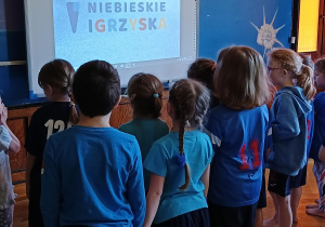 dzieci na tle logo "niebieskich igrzysk"