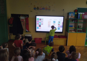 dzieci podczas rozwiązywania zagadek na tablicy multimedialnej