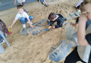 dzieci poszukujące kości dinozaura