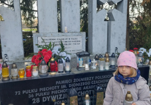 Dziewczynka zapalająca znicz bohaterom