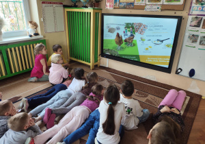 Dzieci oglądają film edukacyjny dla dzieci ,,Produkty ekologiczne''.