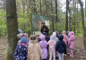 dzieci podczas spaceru ścieżką edukacyjną wraz z przewodnikiem