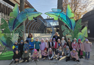 Na zdjęciu grupa Pszczółek pozuje na tle budynku Orientarium.