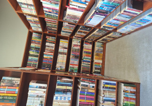 Na zdjęciu znajdują się regały z książkami w bibliotece.