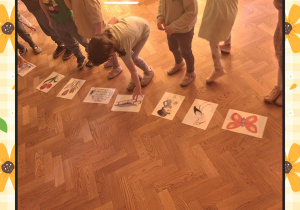 Na zdjęciu dzieci oglądają obrazki dotyczące zwiastunów wiosny.