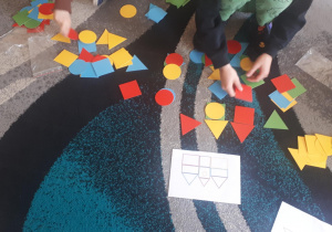 Na zdjęciu dzieci wyklejają plasteliną szablon kwadratu.