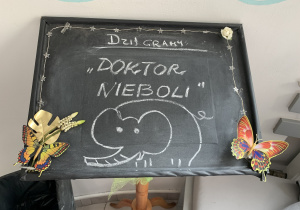 Na zdjęciu czarna tablica przed wejściem na widownię z napisem biała kredą " dzisiaj gramy: Doktor Nieboli"