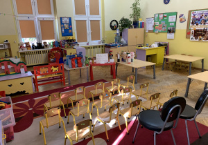 Na zdjęciu: ustawione małe , ponumerowane krzesełka, jak na widowni w teatrze, stolik na którym stoi teatrzyk kukiełkowy, drugi stolik z napisem KASA, trzeci stolik, na którym stoją pacynki