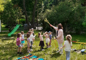 nauczycielka puszczająca bańki grupie dzieci