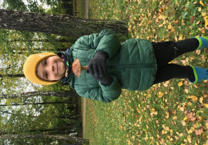 Chłopiec z własnoręcznie zebranym grzybem na spacerze w lesie