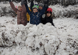 Słoneczka z grupy VI prezentują ulepiony ze śniegu murek do igloo.